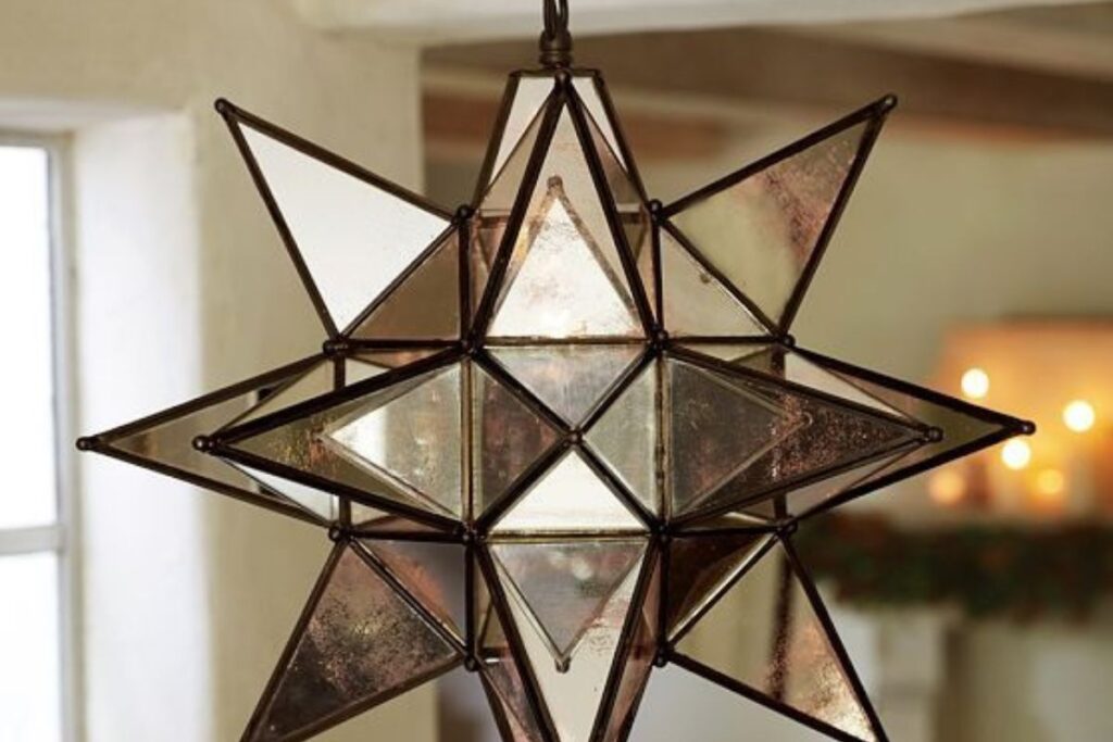 A large, intricate Moravian Star light fixture, featuring metallic points and a dramatic display, illuminating a spacious room.