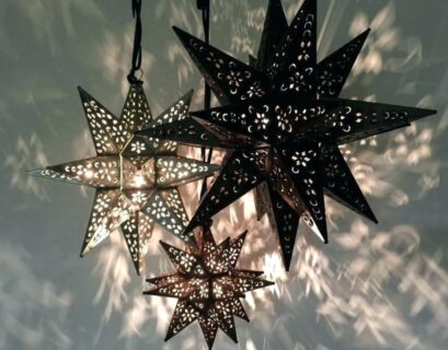 Moravian Star Lights with intricate cut-out designs, casting beautiful patterns on the wall, adding unique lighting to home decor.