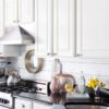 Kitchen with a stylish shiplap backsplash, featuring white wooden panels, modern appliances, and a clean, elegant design.