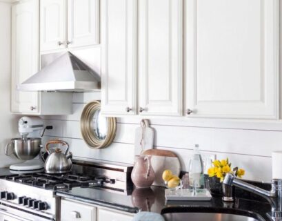 Kitchen with a stylish shiplap backsplash, featuring white wooden panels, modern appliances, and a clean, elegant design.