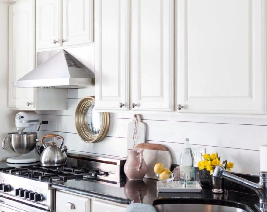 Kitchen with a stylish shiplap backsplash, featuring white wooden panels, modern appliances, and a clean, elegant design.